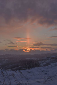 Scenic view of snow covered landscape at sunset