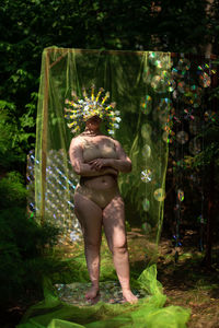 Portrait a woman in a reflective mask in a beige bikini against the background of a cd / dvd case