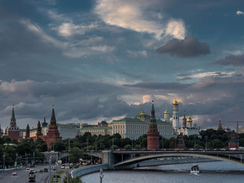 Spasskaya tower by moscva river against cloudy sky