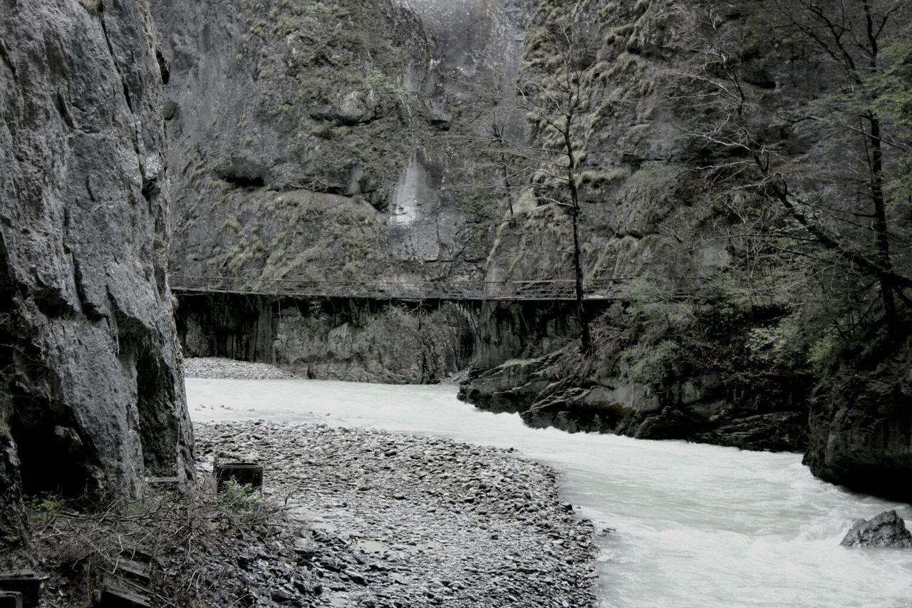 tree, water, nature, rock - object, built structure, snow, winter, tranquility, architecture, beauty in nature, rock formation, day, cold temperature, no people, outdoors, scenics, tranquil scene, weather, river, non-urban scene