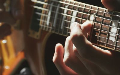 Midsection of man playing guitar