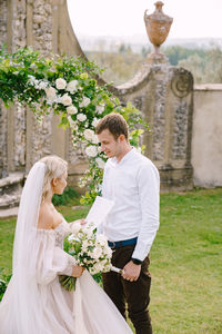 Rear view of couple standing against stone wall