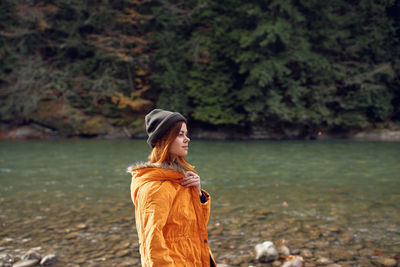 Young woman looking away while standing on land