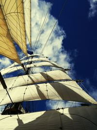 Low angle view of cropped umbrella against blue sky