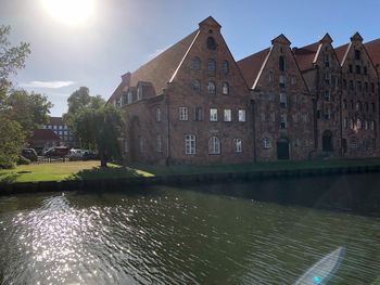 Canal by building against sky