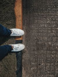 Low section of man standing on road