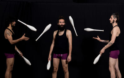 Men juggling while standing at stage