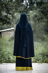 Rear view of woman standing in forest