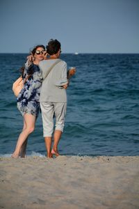 Full length of couple on beach against sea