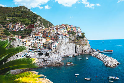 Aerial view of townscape by sea against sky