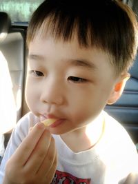 Close-up portrait of cute boy eating food