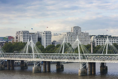 Bridge over river against cloudy sky