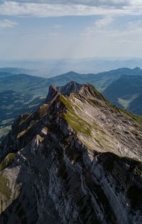 Scenic view of mountain against cloudy sky