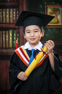 Portrait of happy boy wearing graduation gown