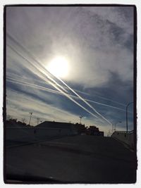 Low angle view of power lines against cloudy sky