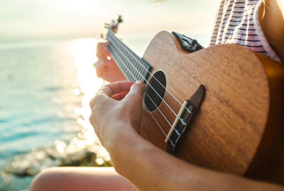 Summer vacation. caucasian women relaxing and playing on ukulele on beach, so happy luxury summer.