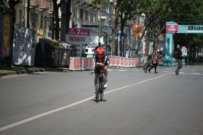 Full length of man riding bicycle on road