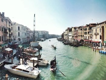 Boats moored in canal against buildings in city