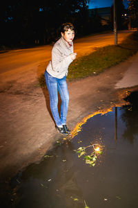 Full length of woman standing by puddle
