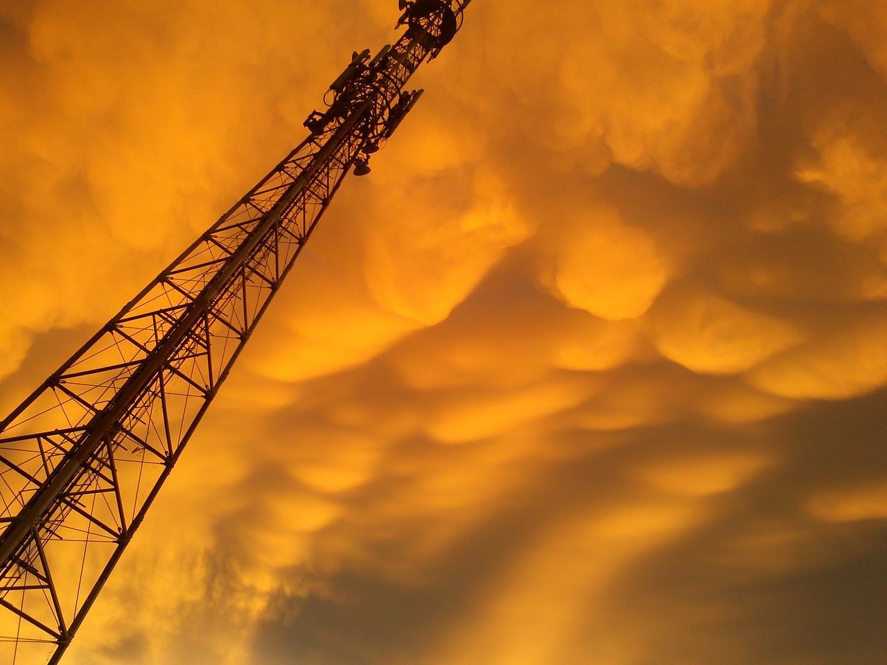 sunset, orange color, low angle view, sky, silhouette, cloud - sky, beauty in nature, nature, dramatic sky, connection, electricity pylon, scenics, cloudy, tranquility, outdoors, electricity, cloud, no people, idyllic, dusk