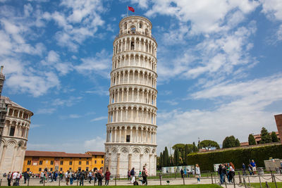 Tourists at the leaning tower of pisa in a beautiful early spring day