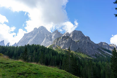 Scenic view of green landscape and mountains against sky