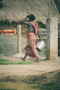 Rear view of woman sitting on field