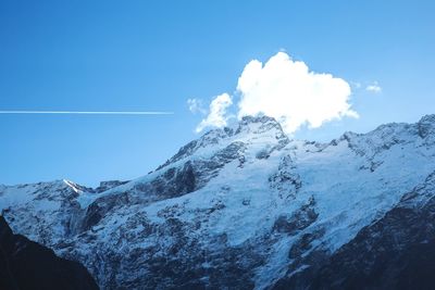 Scenic view of snowcapped mountains against blue sky