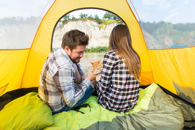 Young couple sitting in tent