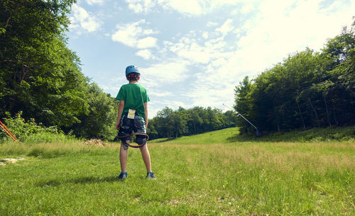 Rear view of man on field against sky