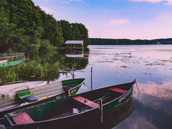 Fishing boat moored on lake against sky