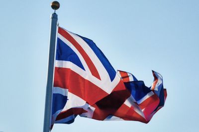 Low angle view of british flag waving against clear sky