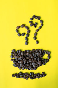 Close-up of coffee beans against yellow background