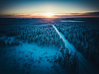 Scenic view of snowy field against sky during sunset