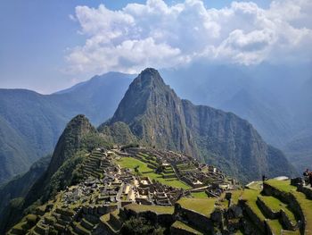 Panoramic view of old ruins on mountain against cloudy sky