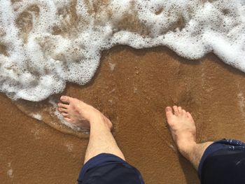 Low section of people standing on beach