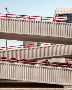 Low angle view of bridge by building against sky