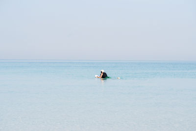 Man doing e foiling around people paddle boarding