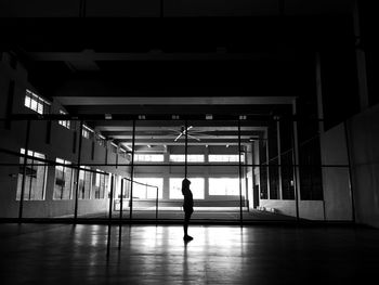 Silhouette of woman standing at tennis court