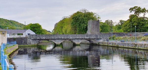 Arch bridge over river against sky