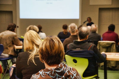 Rear view of people sitting in meeting