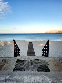 Chair on beach against clear sky