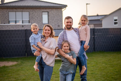 Portrait of happy friends standing on field