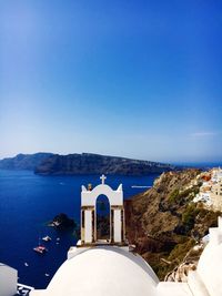 Castle by sea against clear blue sky