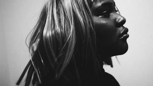 Side view of young woman against white background