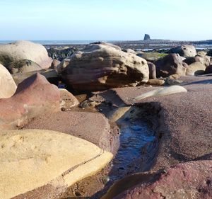 Rocks on beach against sky