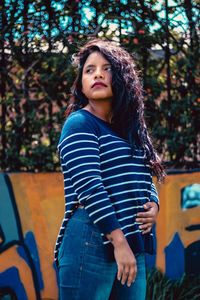 Portrait of woman standing against plants