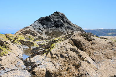 Low angle view of rock formation against clear blue sky