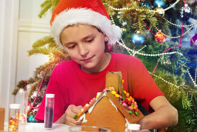 Portrait of young woman holding christmas tree