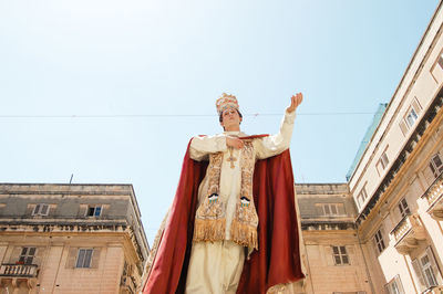 Low angle view of statue against building against clear sky